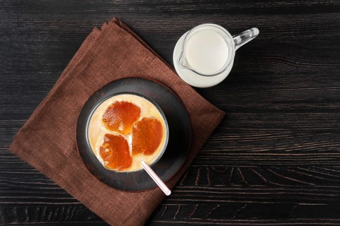 Top view of milk with coffee ice cubes and straw
