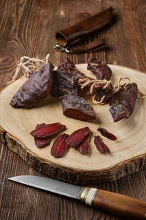 Overhead view of dried jerked deer or venison meat on wooden background