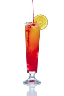 Orange alcohol cocktail with strawberry. Pouring berry liqueur. Isolated on white background