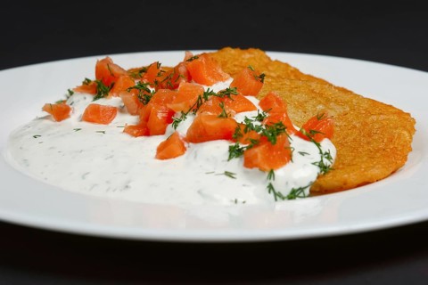 Traditional belorussian potato pancakes with salmon and sour cream