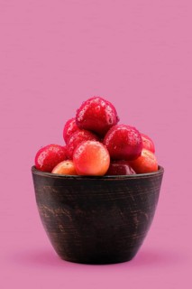 Fresh red cherries in clay bowl
