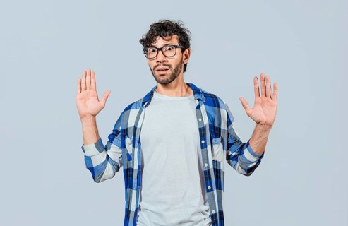 Scared bearded man with raised hands in front. Scared and horrified man with raised palms