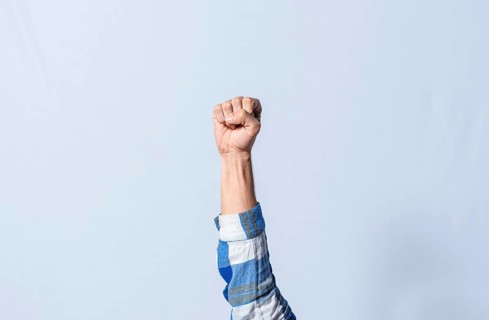 Hand gesturing the letter E in sign language on isolated background. Man hand gesturing letter E of alphabet isolated. Letters of the alphabet in sign language