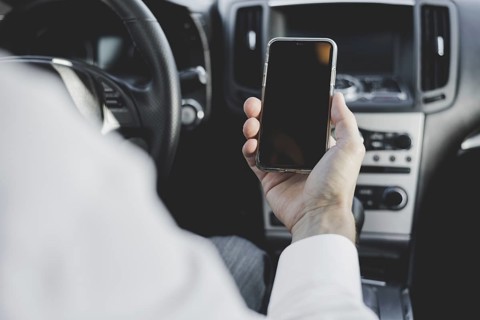 Close up man s hand holding mobile phone with blank screen car