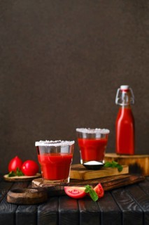 Composition with salty tomato juice on dark wooten table