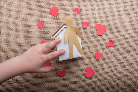 Heart shaped icons and paper house on canvas