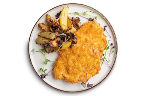 Tasty schnitzel in breading with fried potato