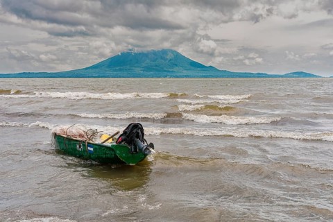 A wooden fishing boat on the shore of a lake