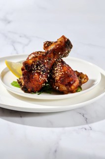 Portion of baked chicken legs with spicy sauce on a plate