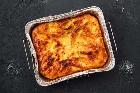 Georgian pie with cheese achma on black wooden background
