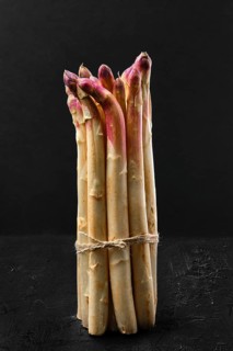 Bunch of asparagus stalks on black background
