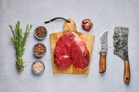 Overhead view of raw fresh deer boneless ham with spice and herb over concrete background