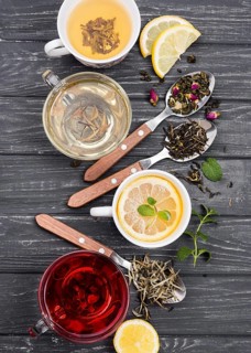 Cup with tea herbs beside
