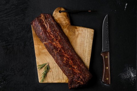 Top view of smoked beef striploin meat on cutting board