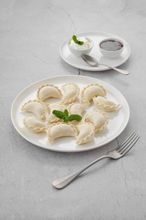 Frozen semifinished vareniki stuffed with cherry on grey background