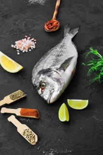 Dorada fish on the table with spice and herbs