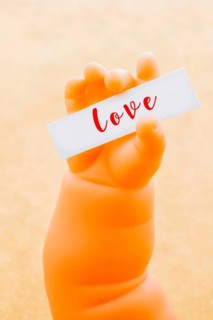 Toy doll hand holding paper with LOVE wording