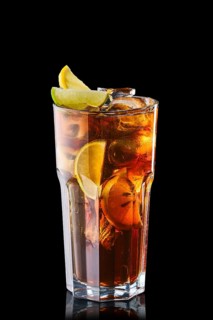 Cold cola with slices of lime and lemon isolated on black background