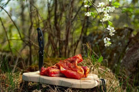 Fresh pork ribs with salt and pepper on cutting board outdoor. Selective focus photo