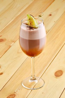 Latte macchiato with apple in transparent glass on wooden background