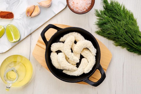 Top view of prepared for frying uncooked shrimps in cheese breading with spice