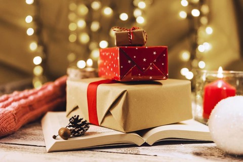 Present boxes book near burning candle