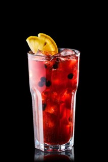 Cold lemonade with orange juice and black currant isolated on black background