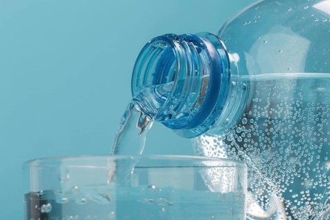 Pouring sparkling water in cup