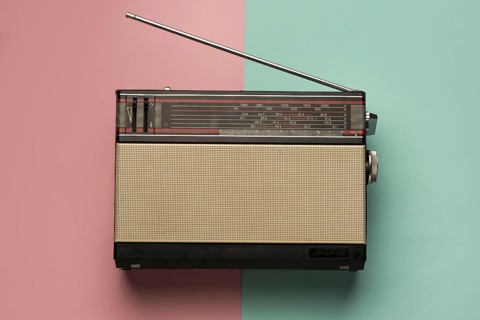 Retro broadcast radio receiver pink light blue background