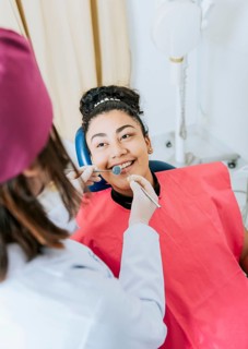 Patient lying on chair smiling at dentist