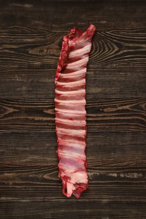 Overhead view of raw deer ribs over wooden background