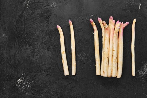 Bunch of asparagus stalks on black background