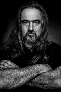 Man with long hair and hand with folded arms