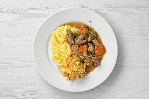 Top view of plate with chicken liver with mashed potato and pickled cabbage salad