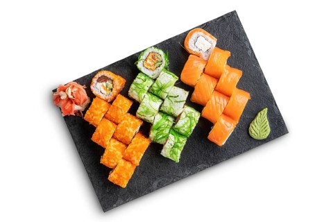 Set of rolls with wasabi and pickled ginger on stone serving board