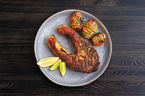 Plate with baked salmon steak with hasselback potatoes
