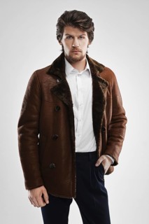 Brutal handsome unshaven man with beard and moustache in sheepskin coat with fur collar
