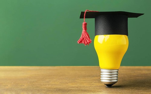 Front view lightbulb with academic cap copy space