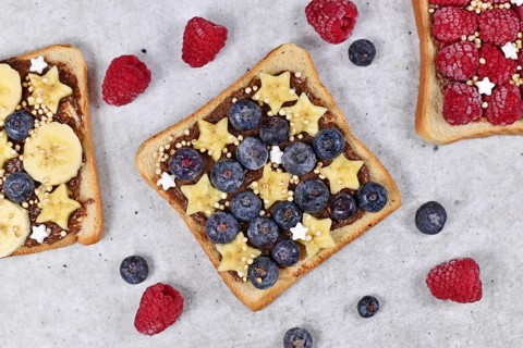 Healthy food with slices of fruit spelt toast bread topped with blueberry and banana and puffed quinoa grains