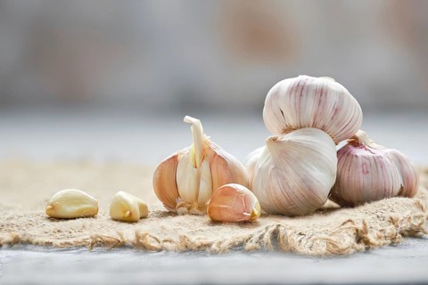 Garlic cloves and bulbs on wooden cutting board