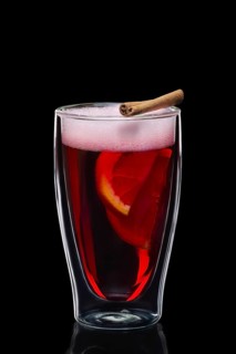 Double-walled glass with hot mulled wine isolated on black