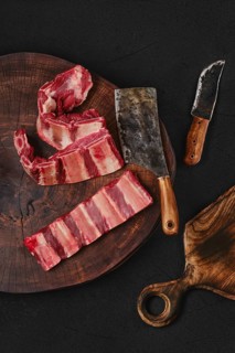 Raw fresh beef short rib stripes on wooden chopping slab