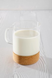 Glass of milk on white wooden kitchen table