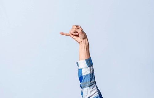Hand gesturing the letter J in sign language on an isolated background. Man's hand gesturing the letter J of the alphabet isolated. Letters of the alphabet in sign language