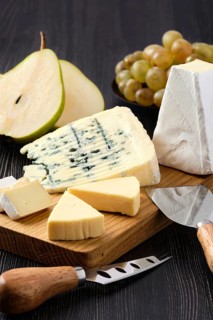 Assortment of cheese and snack for wine on dark wooden table