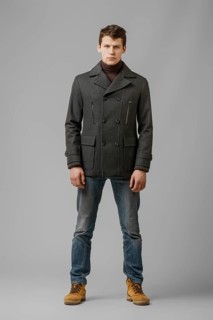 Full length portrait of handsome man in warm woolen coat posing in studio
