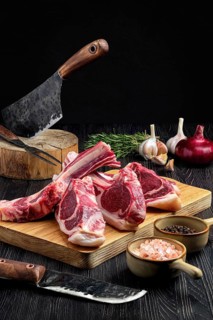 Fresh raw rack of lamb on cutting board with spice
