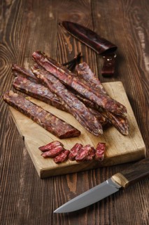Air dried homemade beaver sausages on wooden background