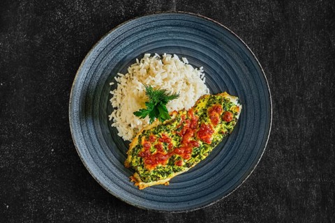 Top view of fried fillet of white fish with spinach and cheese topping and served with rice