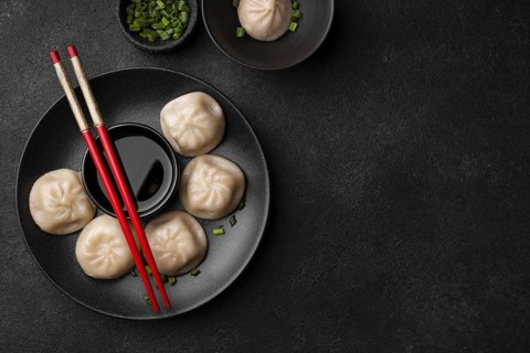 Flat lay asian dumplings with chopsticks copy space